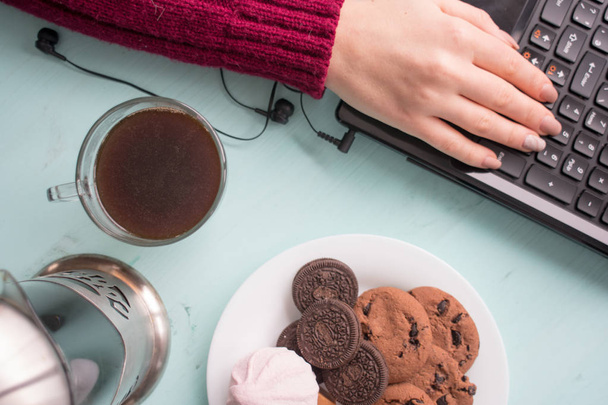 Płyta ciasteczka z czekolada fudge i ptasie mleczko na tle tekstury drewniane w kolorze mięty z kawy i pracy laptopa - Zdjęcie, obraz