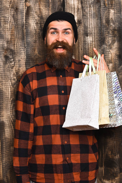Bearded brutal caucasian hipster with moustache holding shopping packages - Photo, Image