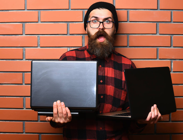 Bearded brutal caucasian hipster holding laptops - Photo, image