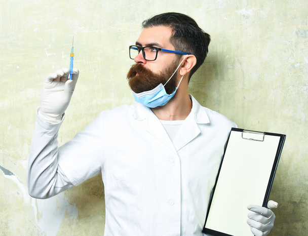 Bearded brutal caucasian doctor or postgraduate student holding clipboard - Photo, Image