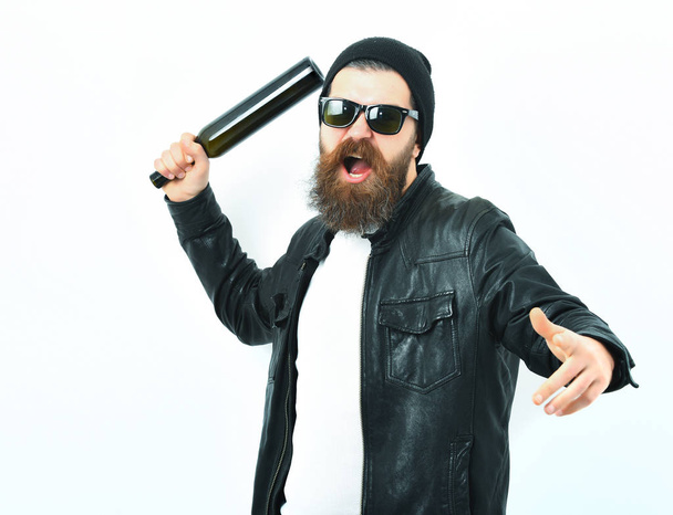 Bearded brutal caucasian hipster holding bottle - Фото, изображение