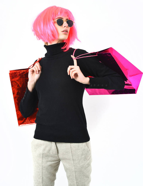 fashionable sexy girl in pink wig holding package or bags - Zdjęcie, obraz