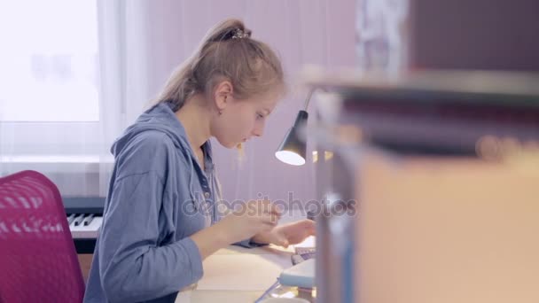 Genç kız bir smartphone kullanarak ev ödevi yapmak - Video, Çekim