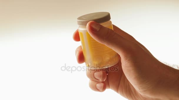 Omega Pills férfi kezében konténer. - Felvétel, videó