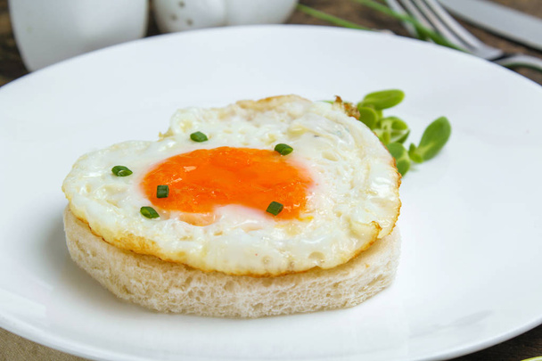 fried egg heart-shaped for breakfast on plate - Photo, Image
