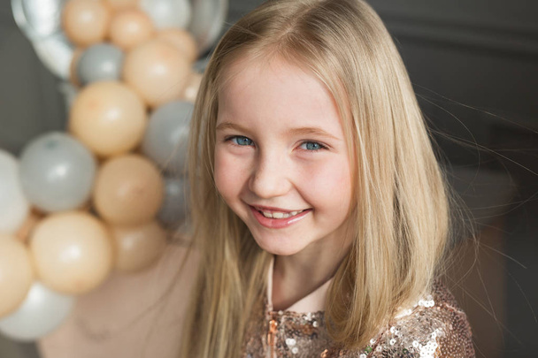 Portrait of smiling little girl with blonde long hair in a studio - Foto, Imagen