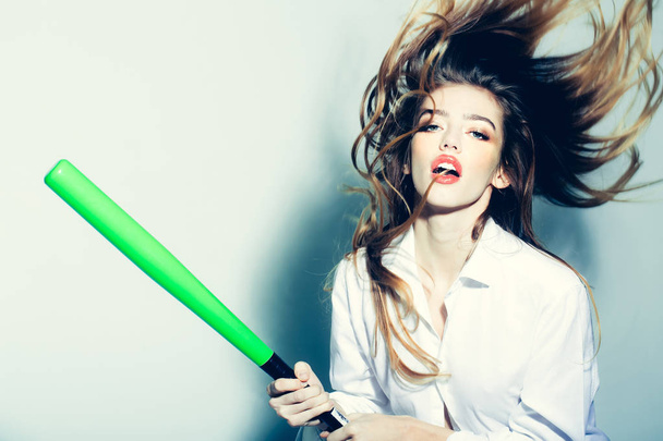 pretty sexy woman with long hair holds green baseball bat - Foto, imagen