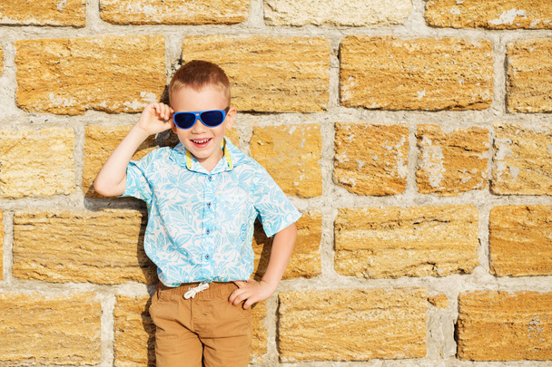 bambino che indossa occhiali da sole a specchio blu contro il bri giallo
 - Foto, immagini