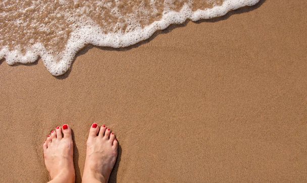 Πόδια των γυναικών σταθείτε πάνω στην καλοκαιρινή άμμο παραλία - Φωτογραφία, εικόνα
