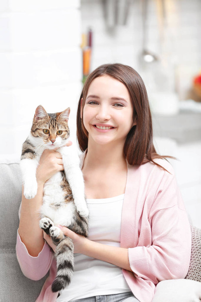 Beautiful young woman with cute cat at home - Foto, Imagen