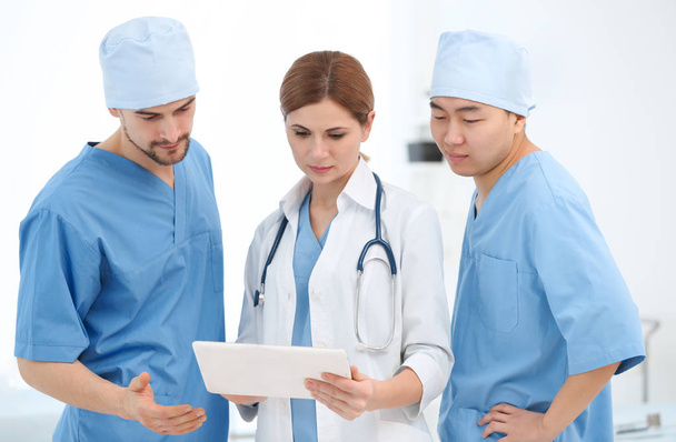 Young doctors with tablet computer in modern clinic - Photo, image