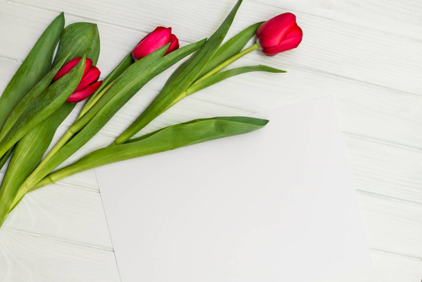 червоні тюльпани на білій дерев'яній дошці
 - Фото, зображення