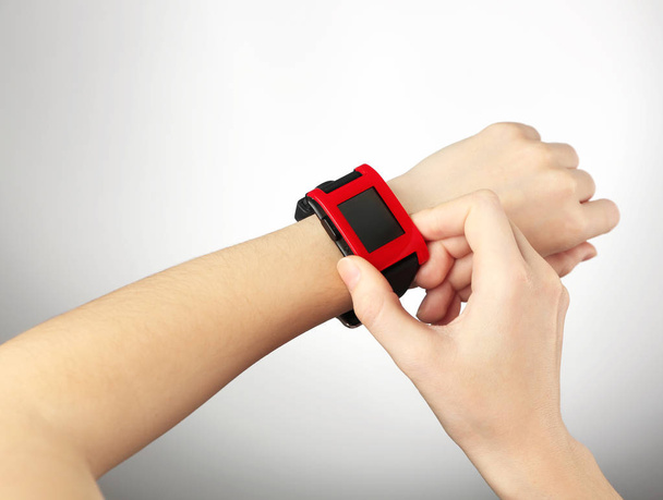 Woman with heart rate monitor watch on light background - Photo, image