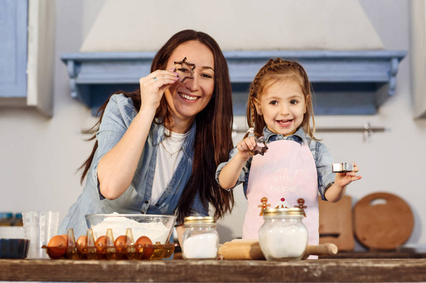 Long haired woman and little girl with shapes for bakery - Photo, Image