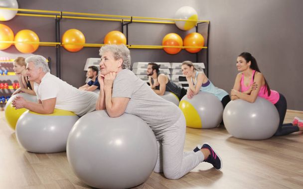 People of different ages training with fit balls in gym - Foto, Bild