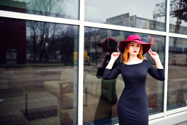 Portrait of fashion red haired girl on red hat and black dress w - Фото, изображение