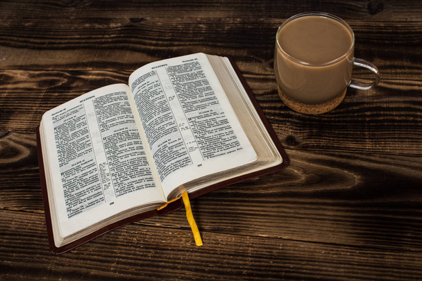Αγία Γραφή και καφέ με γάλα σε φόντο ξύλινη - Φωτογραφία, εικόνα