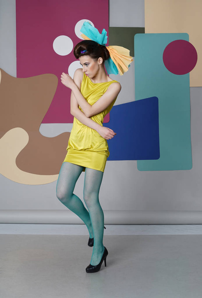 Giovane ragazza in abito corto che si muove sullo sfondo multicolore
. - Foto, immagini