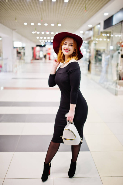 Fashion red haired girl wear on black dress and red hat with lad - Fotó, kép
