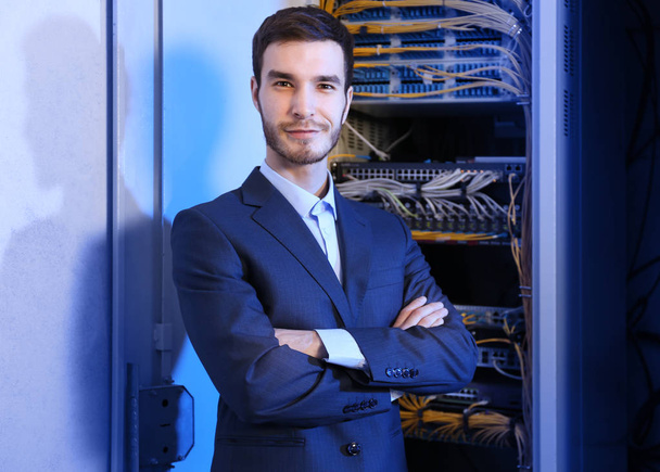 Handsome young engineer in server room - Foto, afbeelding