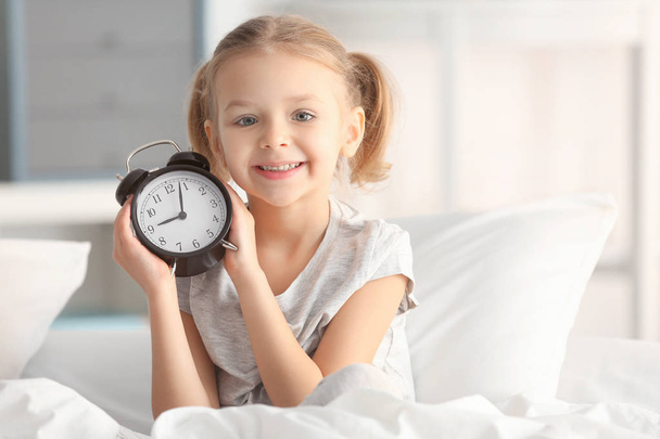 little girl with alarm clock  - Фото, изображение