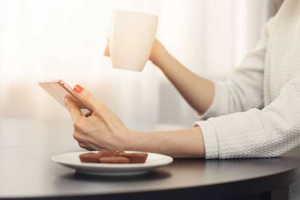 Frau trinkt Kaffee und nutzt digitales Tablet zu Hause - Foto, Bild