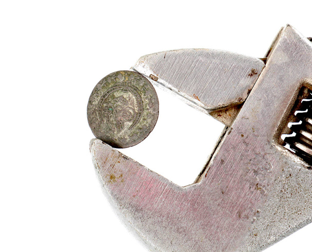 moeda velha pressionada com chave de tubo ajustável
 - Foto, Imagem