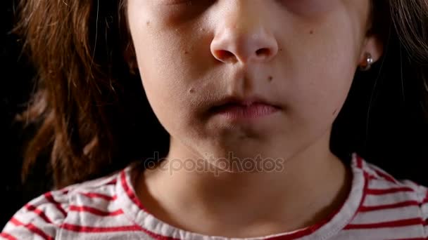 Huiselijk geweld concept. Portret van een jong meisje op zwarte achtergrond. Mens zijn hand op haar mond zetten. - Video
