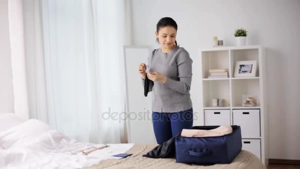 woman packing travel bag at home or hotel room - Filmati, video
