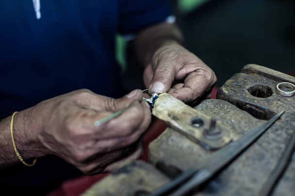 Jewelry making with professional tools. Putting the diamond on the ring. Handmade jewelry process, manufacture of jewellery. Closeup.Soft selective focus - Photo, Image
