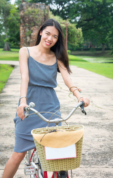 Tyttö ratsastus polkupyörällä Ayutthaya kaupunginpuistossa, Thaimaa
 - Valokuva, kuva