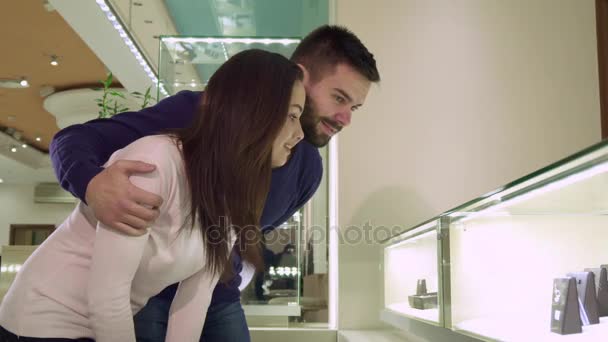 Ζευγάρι κοιτάζει την εμπορική εμφάνιση με κοσμήματα από το κατάστημα - Πλάνα, βίντεο