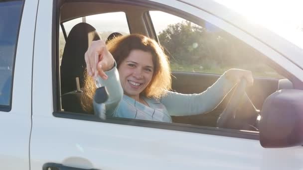 Młoda kobieta wyświetlone jest kluczem do nowego samochodu - Materiał filmowy, wideo