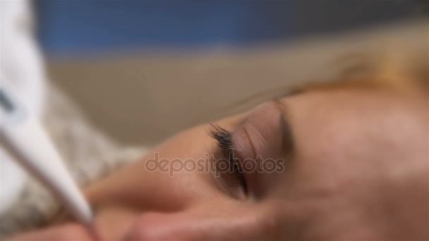 Kobieta z gorączką leży na kanapie z termometrem w ustach. Dolly - Materiał filmowy, wideo