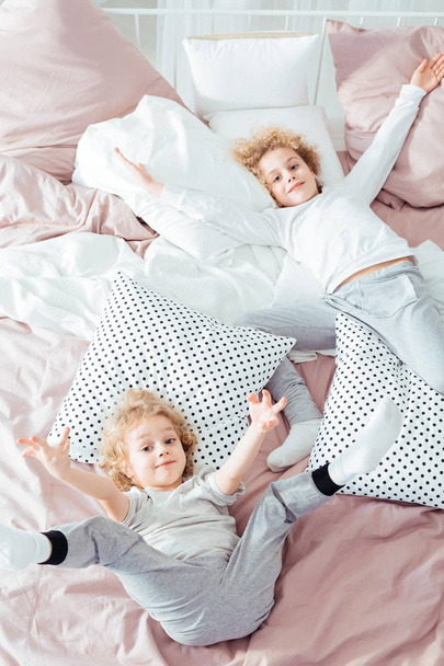 Hermanos pequeños acostados en la cama
 - Foto, Imagen