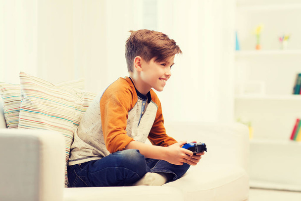 happy boy with joystick playing video game at home - Valokuva, kuva
