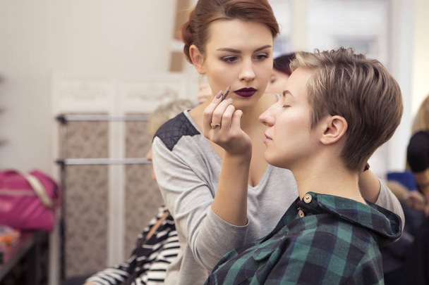 Magnifique femme brune maquilleuse appliquer maquillage à un beautif
 - Photo, image