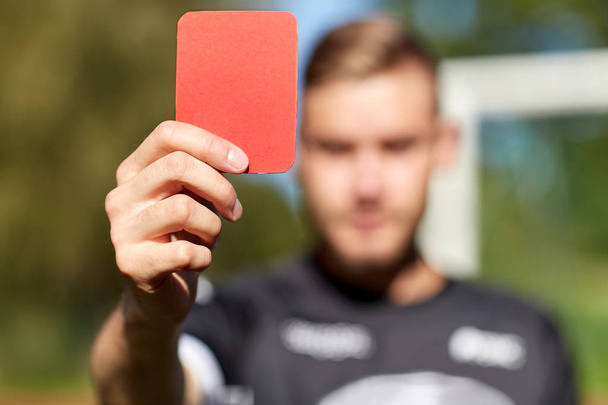 referee hands with red card on football field - Foto, Bild