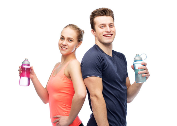 sportive man and woman with water bottles - Zdjęcie, obraz