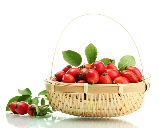 ripe hip roses with leaves in basket, isolated on white - Fotó, kép