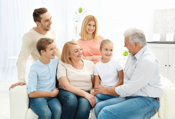 šťastná rodina sedí na pohovce v obývacím pokoji - Fotografie, Obrázek