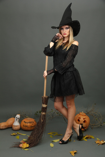 Halloween witch with broom on gray background - Foto, Imagen