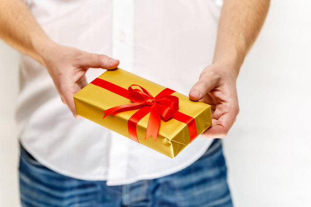 Male hands holding a gift box with ribbon. - Foto, Imagem