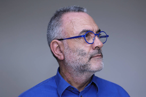 Keski-ikäinen mies sininen paita ja lasit
 - Valokuva, kuva