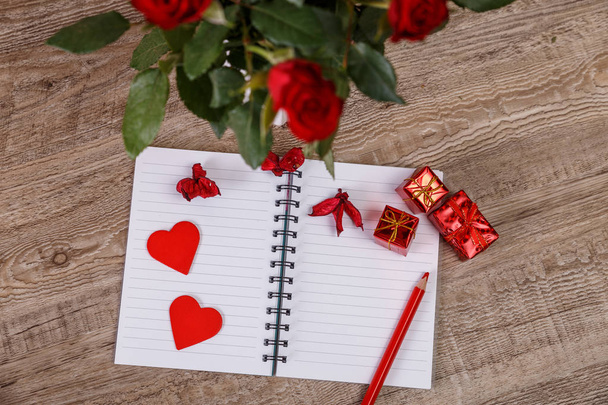 Red roses with hearts, gift boxes and notebook. - Foto, Bild