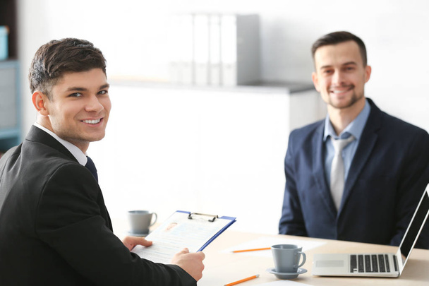 HR-manager interviewen jonge man in kantoor - Foto, afbeelding