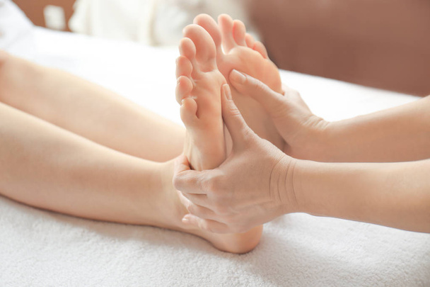 Young woman receiving foot massage in spa salon - 写真・画像