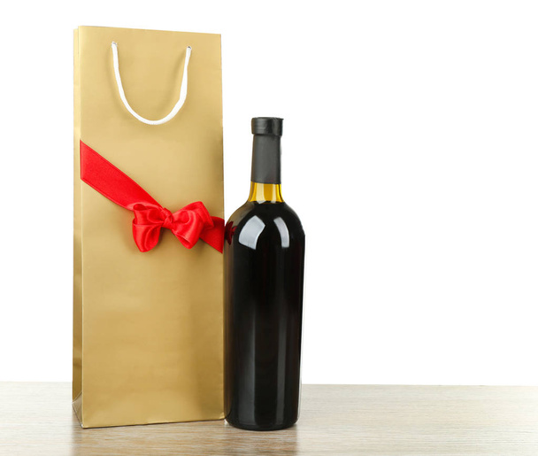 Wine bottle and gift bag on white background - Фото, зображення