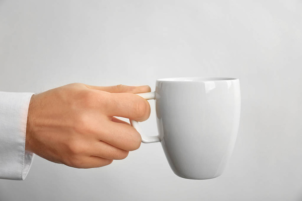 Male hand holding cup - Fotó, kép