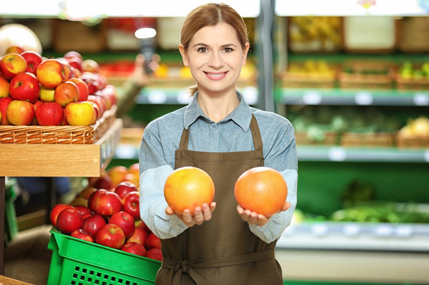 Beautiful saleswoman with fruits - Photo, image